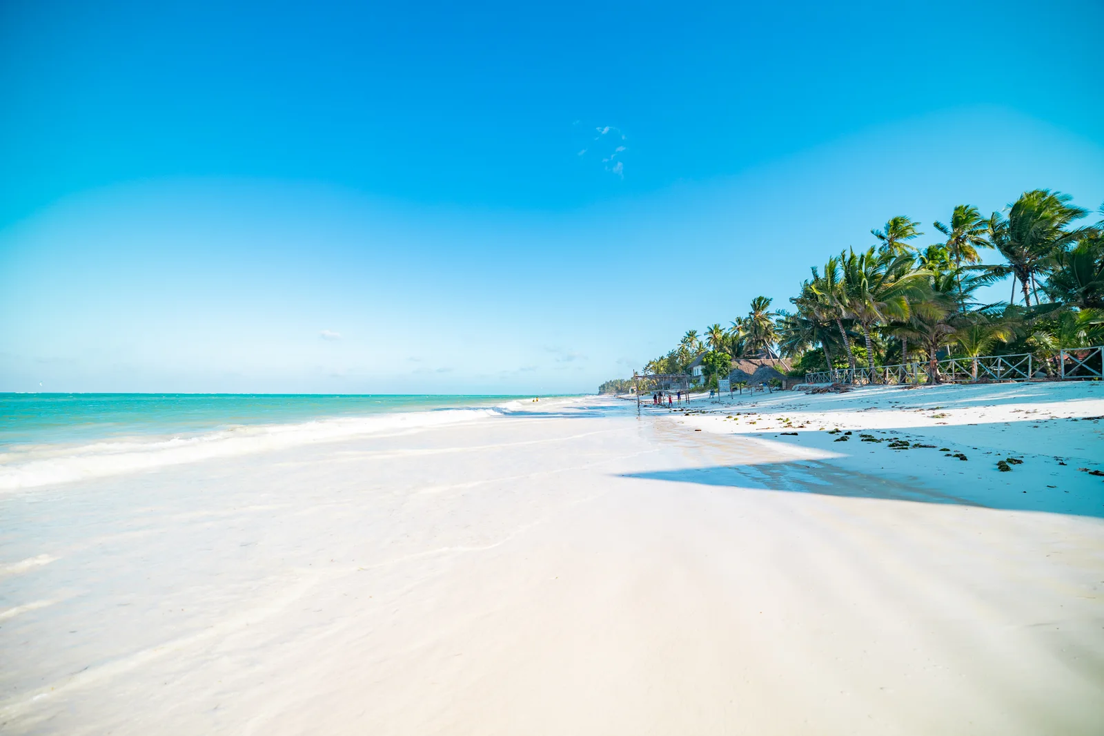 The full sweep of Bwejuu beach, with turquoise ocean and palm trees at Mayai Ocean Resort